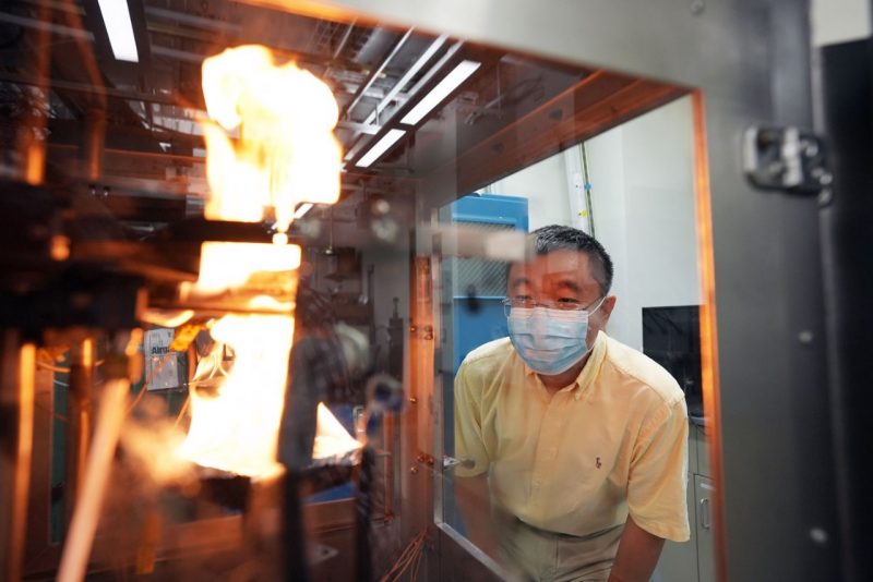 Rui Qiao observes a flame in a collaboration with the EXTREME Lab.
